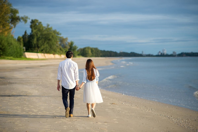 海岸沿いを歩く日本人男性とフィリピン女性のカップル